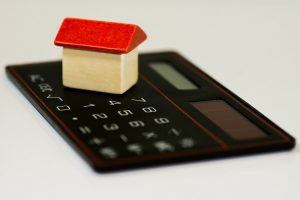 tiny wood house on top of calculator