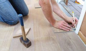 man measuring floor tiles